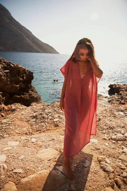 Derya wearing a red beach dress on the beach