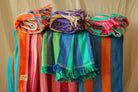 Colorful striped Turkish towels displayed on a stand against a beige background